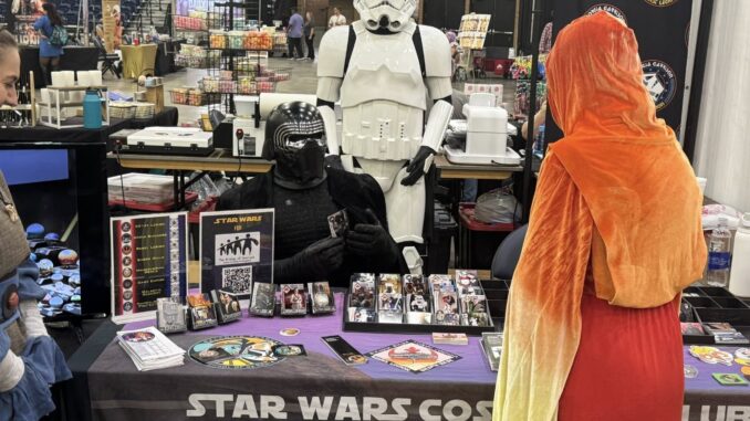 510919517_752537690764815_628255860892597470_n Kylo Ren sitting at a convention table